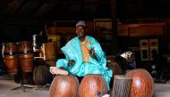 Oumarou Adamou, alias “Maïdouma”, a traditional Nigerien percussionist artist, player and manufacturer of membranophone instruments, makes music in his workshop located within the Professional Music Training Center (CFPM) in Niamey, on October 25, 2023. (Photo by Boureima Hama / AFP)