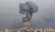 A smoke plume erupts over Khan Yunis from Rafah in the southern Gaza strip during Israeli bombardment on January 8, 2024. (Photo by AFP)