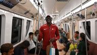 Commuters travel in a metro in Doha on January 11, 2024, on the eve of the AFC Qatar 2023 Asian Cup Group A football inaugural match between Qatar and Lebanon. (Photo by HECTOR RETAMAL / AFP)
