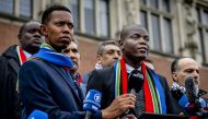 South Africa's Minister of Justice Ronald Lamola (R) delivers remarks to journalists outside the International Court of Justice (ICJ) after the first day of hearing on the genocide case against Israel brought by South Africa, in The Hague on January 11, 2024. (Photo by Remko de Waal / ANP / AFP)