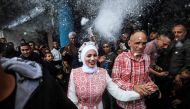 Palestinian bride Afnan Jibril (C) is escorted by her father (C-R) during her wedding at the UNRWA School in the al-Salam neighborhood of Rafah, southern Gaza Strip, on January 12, 2024. (Photo by AFP)