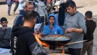 People prepare food in Rafah on the southern Gaza Strip on January 14, 2024. Photo by AFP