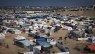 Displaced Palestinians gather at a makeshift camp on the Egyptian border, west of Rafah in the southern Gaza Strip on January 14, 2024. Photo by AFP