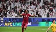 Qatar's forward #11 Akram Afif celebrates after scoring his team's first goal as Tajikistan's goalkeeper #01 Rustam Yatimov reacts during the Qatar 2023 AFC Asian Cup Group A football match between Tajikistan and Qatar at the Al-Bayt Stadium in Al Khor, north of Doha on January 17, 2024. (Photo by HECTOR RETAMAL / AFP)
