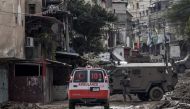 An Israeli soldier gestures towards a Palestinian Red Crescent ambulance at the entrance of the Tulkarem refugee camp in Tulkarem, in the occupied West Bank, on January 17, 2024. (Photo by Marco Longari / AFP) 