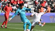 South Korea's goalkeeper #01 Kim Seung-gyu secures the ball from Bahrain's midfielder #07 Ali Madan during the Qatar 2023 AFC Asian Cup Group E football match between South Korea and Bahrain at the Jassim bin Hamad Stadium in Doha on January 15, 2024. (Photo by HECTOR RETAMAL / AFP)
