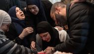 The mother (C) of 17-year-old Palestinian Tawfeek Ajaq mourns over his body ahead of his funeral procession on January 20, 2024. (Photo by Marco Longari / AFP)