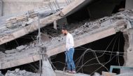 A Palestinian man stands on the rubble of a family home, demolished by Israeli forces earlier during a raid in Hebron city in the occupied West Bank on January 21, 2024.  (Photo by Mosab Shawer / AFP)