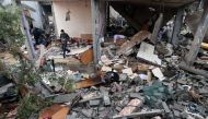 A young man salvages objects amid the rubble of a building destroyed by Israeli bombing in Rafah in the southern Gaza Strip on January 27, 2024. (Photo by AFP)
