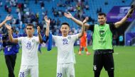 Uzbekistan's players celebrates with their fans after the Qatar 2023 AFC Asian Cup football match between Uzbekistan and Thailand at Al-Janoub Stadium on January 30, 2024. (Photo by Karim Jaafar / AFP)