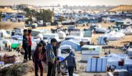 Children stand atop a small hill near tents at a make-shift shelter for Palestinians who fled to Rafah in the southern Gaza Strip on January 30, 2024. 