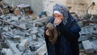 A woman reacts upon finding clothing items of a killed relative among rubble of a destroyed house, following Israeli bombardment in Rafah in the southern Gaza Strip on February 3, 2024. Photo by Mohammed ABED / AFP