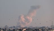 A picture taken from Rafah in the southern Gaza Strip shows smoke rising over buildings in Khan Yunis following Israeli bombardment on February 5, 2024. (Photo by Said Khatib / AFP)