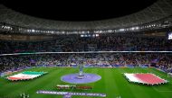 Qatar's players (center R) and Iran's players (center L) line-up in front of a large-scale Qatar 2023 AFC Asian Cup trophy replica before the start of the Qatar 2023 AFC Asian Cup semi-final football match between Iran and Qatar at al-Thumama Stadium in Doha on February 7, 2024. Photo by KARIM JAAFAR / AFP