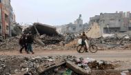 Men walk along a street ravaged by Israeli bombing in Rafah in the southern Gaza Strip on February 9, 2024. (Photo by Mohammed ABED / AFP)