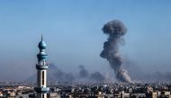 A picture taken from Rafah shows smoke billowing during Israeli bombardment over Khan Yunis in the southern Gaza Strip on February 11, 2024. (Photo by Said Khatib / AFP)