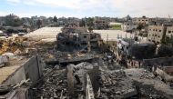 Palestinians inspect the damage amid the rubble of a building bombed in Rafah, on the southern Gaza Strip on February 12, 2024. (Photo by Said Khatib / AFP)