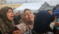 Women mourn after the death of relatives in an Israeli air strike that hit the Baraka family home in Deir al-Balah in the central Gaza Strip on February 18, 2024. (Photo by AFP)