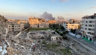 A picture taken in Gaza City shows debris from destroyed buildings and smoke billowing in the background during Israeli bombardment on February 20, 2024. (Photo by AFP)