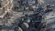 Palestinian men check the rubble of the al-Faruq mosque on February 22, 2024, following an overnight Israeli air strike in Rafah refugee camp in the southern Gaza Strip. (Photo by Said Khatib / AFP)