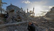  A man sits amid the debris of destroyed houses in the aftermath of Israeli bombardment in Rafah in the southern gaza Strip on February 22, 2024. (Photo by MOHAMMED ABED / AFP)