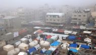 Fog covers buildings and tents set up by displaced Palestinians in Rafah in the southern Gaza Strip on February 25, 2024. (Photo by Said Khatib / AFP)