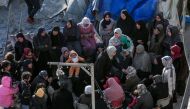 Palestinians sit amid tents and makeshift shelters that were destroyed in Israeli strikes in Deir El-Balah in central Gaza on March 2, 2024, as battles continue between Israel and the militant group Hamas. (Photo by AFP)
