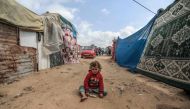 A child plays in a makeshift camp for displaced Palestinians in Deir al-Balah in central Gaza on March 3, 2024. Photo by AFP