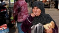 A Palestinian woman eats bread in Rafah in the southern gaza Strip on March 4, 2024 (Photo by AFP)