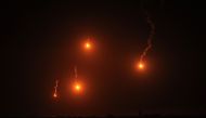 This picture taken from Rafah shows flares lighting the skies over Khan Yunis in the southern gaza Strip on March 4, 2024. (Photo by SAID KHATIB / AFP)
