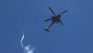 An Israeli military helicopter firing a flare over Gaza on March 7, 2024. (Photo by Jack Guez / AFP)