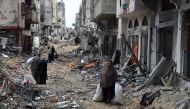 Palestinians carry some of their belongings after returning briefly to Khan Yunis in the southern Gaza Strip to check on what remains of their homes on March 7, 2024. Photo by AFP