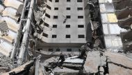 A Palestinian boy inspects the damage to a building hit in an Israeli strike in Rafah, in the southern Gaza Strip on March 10, 2024. (Photo by Mohammed Abed / AFP)
 