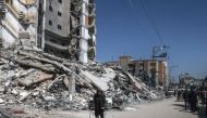 Palestinians walk past the rubble of a destroyed building due to Israeli bombardment on the second day of Ramadan in Rafah. Photo by MOHAMMED ABED / AFP