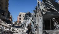 A Palestinian man walks through the rubble of a destroyed building due to Israeli bombardment in Rafah in the southern Gaza Strip on the second day of the Muslim holy fasting month of Ramadan on March 12, 2024. (Photo by MOHAMMED ABED / AFP)
