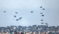 This picture taken from Israel's southern border with the Gaza Strip shows humanitarian aid being airdropped over the Palestinian territory on March 13, 2024. (Photo by Jack Guez / AFP)