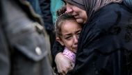 A Palestinian woman holds a child as they mourn their relatives killed in Israeli bombardment in front of the morgue of the Al-Shifa hospital in Gaza City on March 15, 2024, amid the ongoing conflict between Israel and the Palestinian Hamas movement. (Photo by AFP)