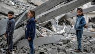 Palestinian children look at the rubble of a building, after it was destroyed in an Israeli strike the night before, in the Rimal neighbourhood of gaza City on March 16, 2024. (Photo by AFP)