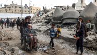 People walk past the rubble of Al-Faruq Mosque, that was destroyed during Israeli bombardment, in Rafah on the southern gaza Strip on March 17, 2024. (Photo by SAID KHATIB / AFP)