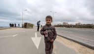 A child reacts as he walks along the coastal highway with other displaced Palestinians fleeing from the area in the vicinity of Gaza City's al-Shifa hospital, upon arrival at the Nuseirat refugee camp in the central Gaza Strip on March 18, 2024. (Photo by AFP)
