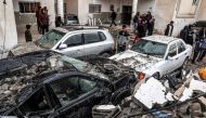 People inspect destroyed vehicles following overnight Israeli bombardment at the Rafah refugee camp in the southern Gaza Strip on March 19, 2024. (Photo by SAID KHATIB / AFP)
