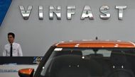 An employee stands under the VinFast logo inside a showroom for the electric vehicle maker in Hanoi on September 29, 2023. Photo by Nhac NGUYEN / AFP