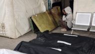 A young Palestinian boy reacts as he sits between a blood-stained mattress and body bags at the al-Najjar hospital, following overnight Israeli bombardment in Rafah in the southern Gaza Strip on March 24, 2024. (Photo by Mohammed Abed / AFP)