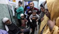 A man carries children injured in Israeli bombardment, at the al-Najjar hospital in Rafah in the southern Gaza Strip on March 24, 2024. (Photo by Mohammed Abed / AFP)