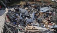 In this aerial view, Palestinians assess the destruction of a house hit by Israeli bombardment in the northern part of Rafah in the southern Gaza Strip on March 23, 2024. (Photo by SAID KHATIB / AFP)
