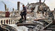 A man salvages the remains of a copy of the Holy Quran from the rubble of a building that was hit overnight during Israeli bombardment in Rafah in the southern Gaza Strip on March 26, 2024. (Photo by Said Khatib / AFP)
