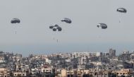 This picture taken from Israel's southern border with the Gaza Strip shows parachutes of humanitarian aid dropping over the besieged Palestinian territory on March 27, 2024. (Photo by Jack Guez / AFP)