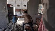 Members of the Abul Aoun family salvage some belongings from the rubble in their home destroyed during Israeli bombardment on the Al-Maghazi refugee camp in Deir Balah in the central Gaza Strip on March 31, 2024. (Photo by AFP)