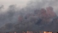 This picture taken from Rafah shows smoke billowing over Khan Yunis in the southern gaza Strip during Israeli bombardment on January 16, 2024 (Photo by Mahmud Hams / AFP)
