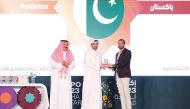 Minister of Municipality H E Abdullah bin Hamad bin Abdullah Al Attiyah (centre) honouring a  representative of Pakistan Pavilion at Expo 2023 Doha. 